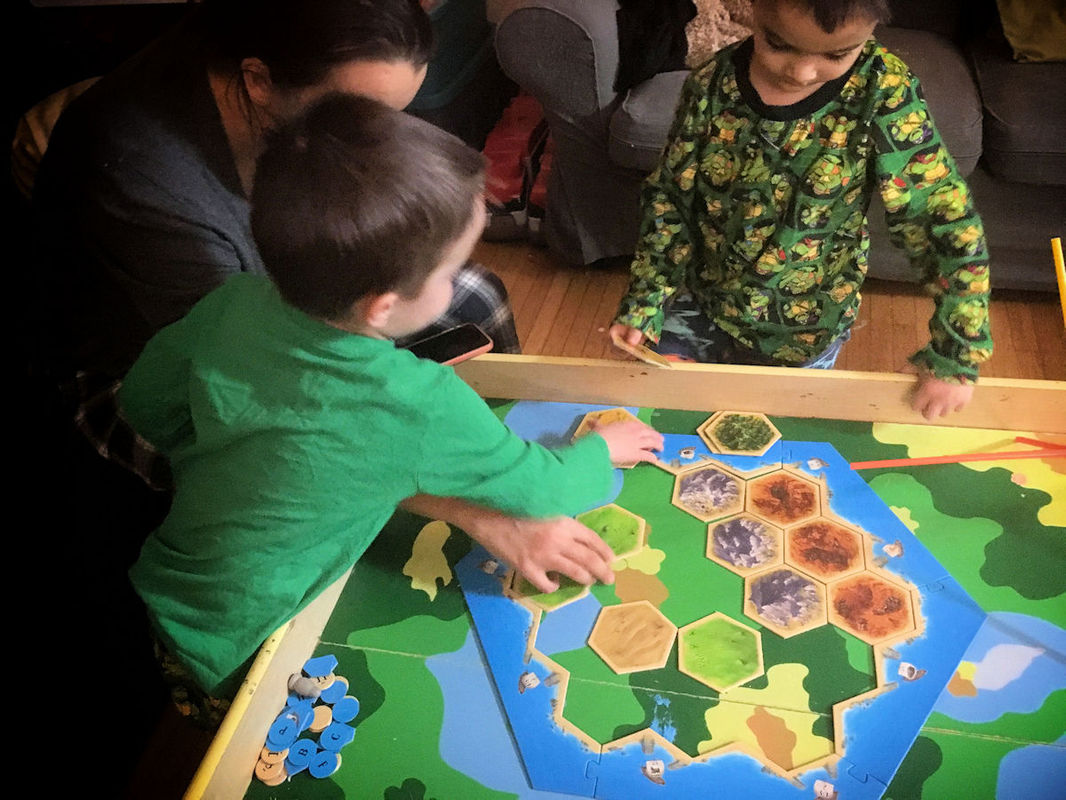 Twin boys playing their first match of Settlers of Catan like Monopoly. A great example of kids making up their own board game rules!